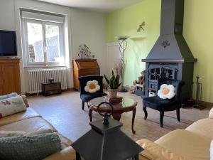 sala de estar con sofá y chimenea en Gites le Rucher de Kerillis, en Plouguiel
