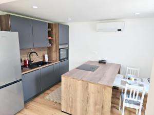 a kitchen with a wooden island in the middle at Charming Bella Hideout - Adults Only in Jesenice