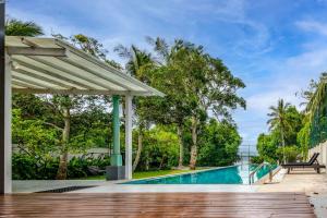 una terraza al aire libre con piscina y un pabellón en Astig Villa - Negombo, en Negombo