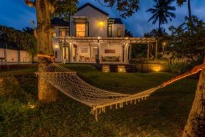 a hammock in front of a house at night at Astig Villa - Negombo in Negombo