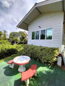 une table et des chaises devant une maison dans l'établissement Min Home, à Lamphun