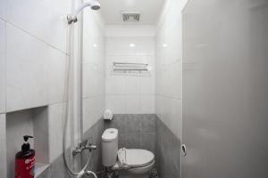 een kleine badkamer met een toilet en een douche bij RedDoorz near Binus Anggrek 2 in Jakarta