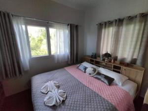 1 dormitorio con 1 cama con toallas en Min Home, en Lamphun