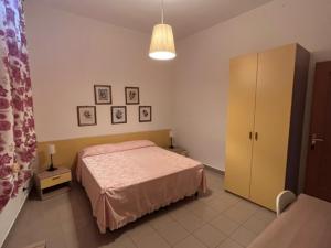 1 dormitorio con 1 cama, armario y lámpara en B&B Casa Miraglia en Chiaromonte