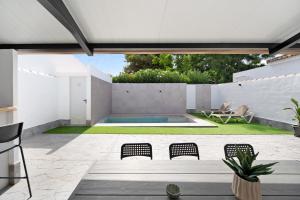 an outdoor patio with a pool and chairs at Ferro Piscina Climatizada in Chiclana de la Frontera