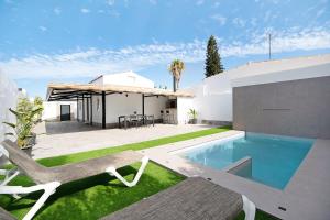 a backyard with a swimming pool and a house at Ferro Piscina Climatizada in Chiclana de la Frontera