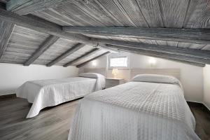 two beds in a room with wooden ceilings at Ferro Piscina Climatizada in Chiclana de la Frontera +37 photos