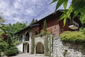 uma casa com uma parede de pedra e hera em Villa Marzia em Lanzo dʼIntelvi