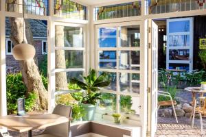 a room with large windows and a table and a desk at OP ZESTIEN in Hippolytushoef +18 photos