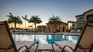 a pool with chairs and palm trees in a resort at Miramar 2BR w gym pool wd nr WF MIA-23 in Miramar