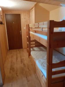 a room with two bunk beds and a door at Grand appartement au pied des pistes au cœur des Rousses in Les Rousses