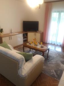 salon z białą kanapą i stolikiem kawowym w obiekcie Apartman Lana w mieście Kijevo