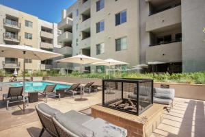 an outdoor patio with a fire pit and a pool at Hollywood 1BR w Gym Pool Spa nr Sunset Blvd LAX-231 in Los Angeles
