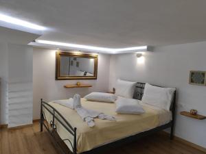 Isidora Apartments في زاغورا: غرفة نوم مع سرير ومرآة على الحائط