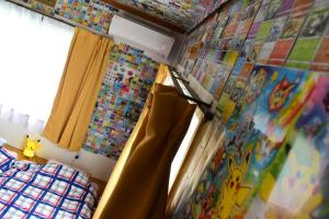 a bedroom with a bed and curtains and a window at OMOLOSO Hostel　オモロソウ ホステル in Beppu