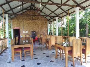 a dining room with wooden tables and chairs at Falcon Jungle Resort in Jyoti Gaon