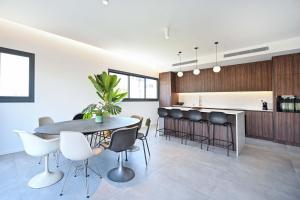 a kitchen and dining room with a table and chairs at Modern 3BR retreat in the Old North by HolyGuest in Tel Aviv