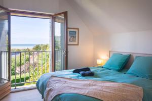 a bedroom with a bed with a view of the ocean at La Villa Maxine, vue mer et spa in Criel-sur-Mer