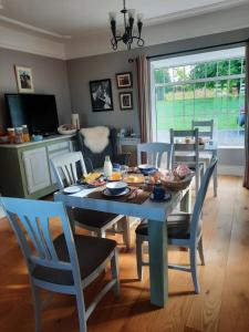 a dining room with a blue table and chairs at Butterhouse in Trim