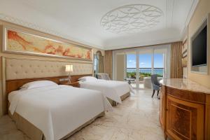 ein Hotelzimmer mit 2 Betten und einem TV in der Unterkunft Crowne Plaza Resort Sanya Bay, an IHG Hotel in Sanya