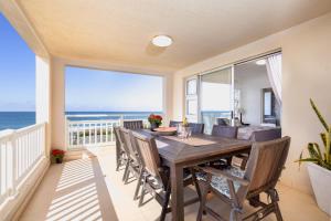 a dining room with a table and views of the ocean at Laguna La Crete 26 in Uvongo Beach