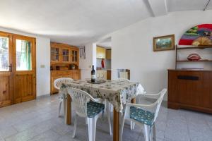 een eetkamer met een tafel en stoelen en een keuken bij Casa Pisaro Lu Bagnu in Castelsardo