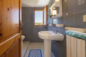 een badkamer met een wastafel en een toilet bij Casa Pisaro Lu Bagnu in Castelsardo