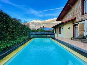 a swimming pool in front of a house at Doodle's Amazing Chalet -Walensee - Flumserberg - Churfirsten - Heidiland - Pool - Sauna in Mols