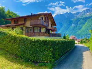 a house on a hedge next to a road at Doodle's Amazing Chalet -Walensee - Flumserberg - Churfirsten - Heidiland - Pool - Sauna in Mols