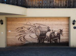 una puerta de garaje con una pintura de un hombre montando un caballo en Doodle's Amazing Chalet -Walensee - Flumserberg - Churfirsten - Heidiland - Pool - Sauna, en Mols