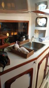 een keuken met een wastafel en een aanrecht met manden bij Vacations in a Sailboat in Lissabon +30 foto's