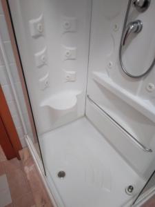 ducha con puerta de cristal y lavamanos en Casa Costantino, en Campanedda