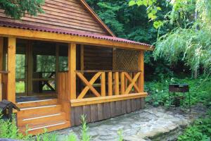 a small wooden cabin with a large window at Zarinok in Pilipets