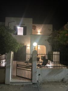 una casa con una cerca y sillas y una luz en CASA APPRODO, en Porto Cesareo