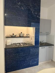 cocina con fogones y pared azul en CASA APPRODO, en Porto Cesareo 2 fotos más