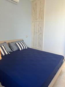 Una cama azul en una habitación con un armario. en CASA APPRODO, en Porto Cesareo