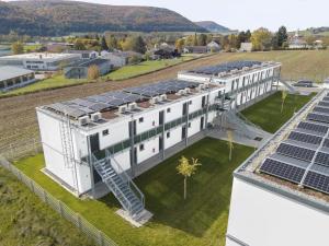 una vista aérea de un edificio con paneles solares en el techo en OHO Rooms Geisingen - Digital Access Only en Geisingen