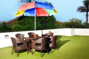 a table and chairs under a colorful umbrella at Garava Villa Lonavala in Khandala