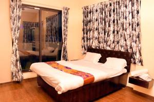 a bed in a room with a window and a bed sidx sidx at Garava Villa Lonavala in Khandala