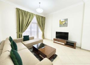 a living room with a couch and a tv at RH- Convenient 1BR, Central, near Mall of Emirates, Al Barsha1 in Dubai