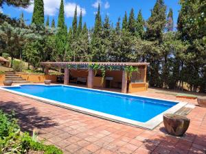 - une piscine dans un jardin avec un kiosque dans l'établissement Casa de campo en el Empordà, à Cruïlles