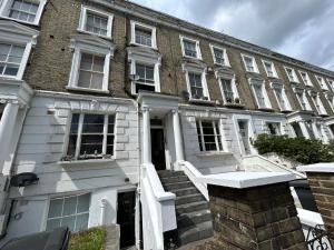 a large brick building with stairs in front of it at Flat 1, 128A Belsize Road NW6 4BG LONDON in London