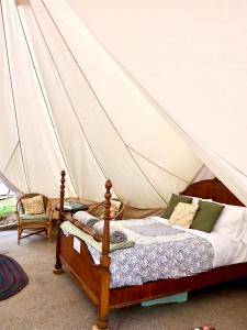 a bedroom with a bed in a tent at The Toad's pad in Tiverton