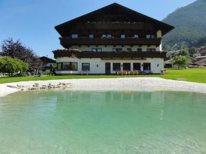 un edificio con una piscina de agua delante en Hotel Steuxner en Neustift im Stubaital