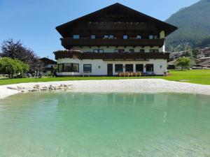 a building with a pool of water in front of it at Hotel Steuxner in Neustift im Stubaital