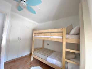 um quarto com 2 beliches e uma ventoinha de tecto em Casa Limonero em Denia