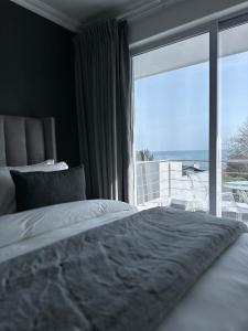 a bedroom with a bed and a large window at The Atlantic DonReal Guesthouse in Cape Town