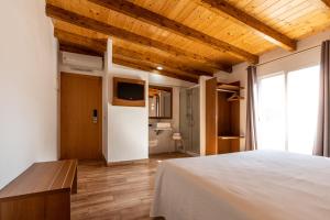 a bedroom with a white bed and wooden ceilings at Hotel Avenida in Benicàssim