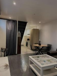 uma sala de estar com uma mesa e uma cozinha em Paisible Duplexe sur Villeneuve d ascq em Annappes