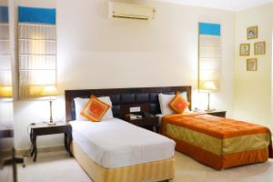 Bansi Home Stay في آغْرا: غرفه فندقيه سريرين ومصباحين